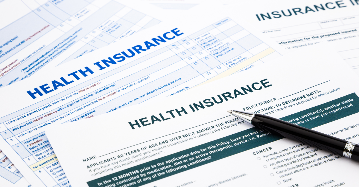 A pile of health insurance program options. There ia a pen laying on top of the pile.