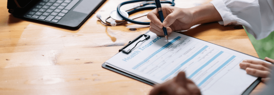 Someone signing a health insurance form.