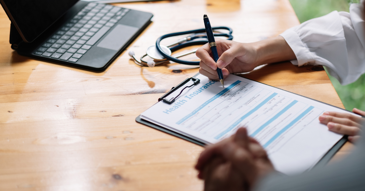 Someone signing a health insurance form.