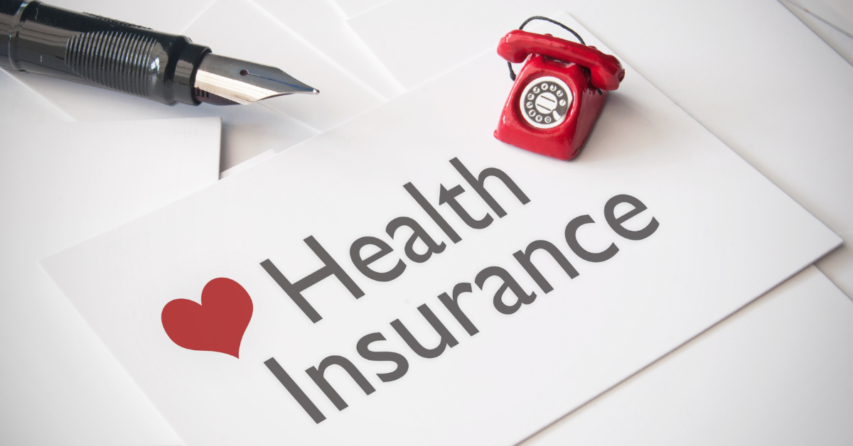 A paper that says "health Insurance" with a red telephone off to a corner.